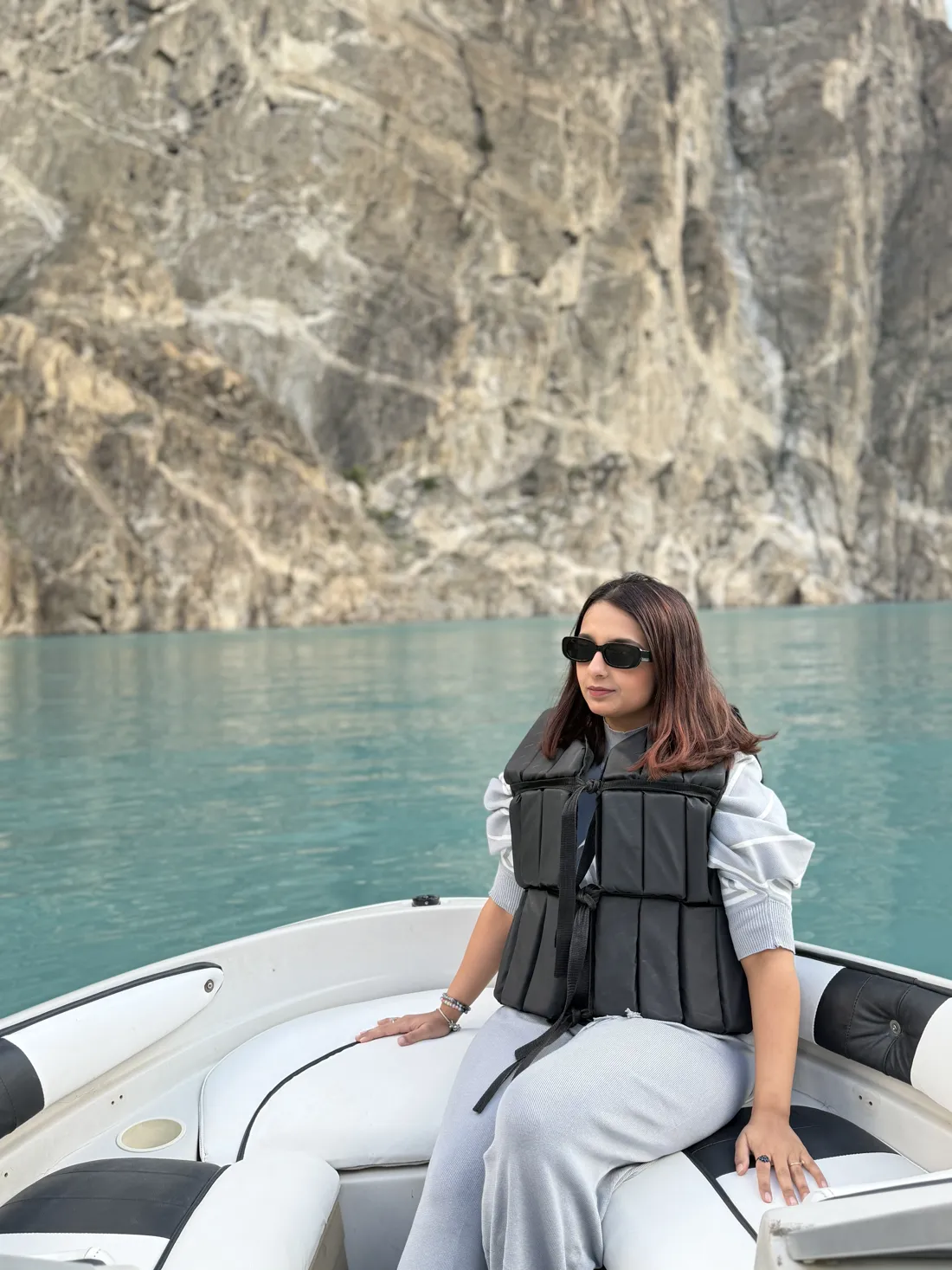 Hadia on a boat on a turquoise mountain lake